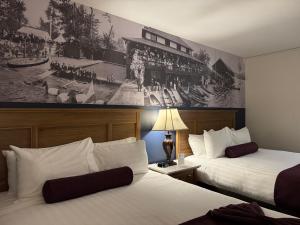 a hotel room with two beds and a painting on the wall at The Royal Anne Hotel in Kelowna +56 photos