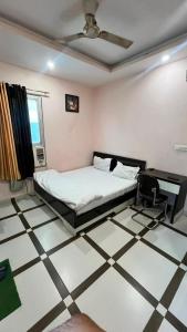 a bedroom with a bed and a tiled floor at Hotel shree govind in Orai