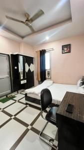 a room with two beds and a desk and a chair at Hotel shree govind in Orai