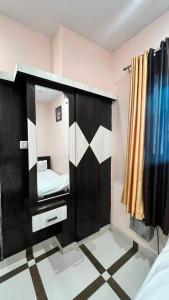 a small room with a mirror and a bed at Hotel shree govind in Orai +3 photos