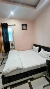 a bedroom with two beds and a window at Hotel shree govind in Orai