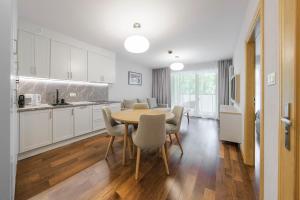 a kitchen and dining room with a table and chairs at Apartamenty MAREA in Jurata