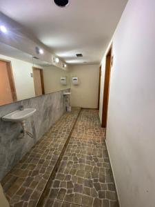 an empty bathroom with a sink and a toilet at Rede Quartos in São Paulo