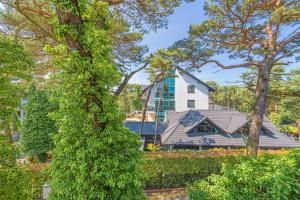a house seen through the trees at Apartamenty MAREA in Jurata