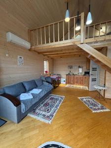 a living room with a blue couch and a kitchen at Forest Hills in Yaremche