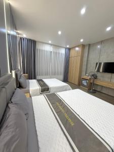a bedroom with three beds and a flat screen tv at Lamer Hostel in Cat Ba