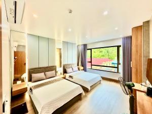a bedroom with two beds and a large window at Lamer Hostel in Cat Ba +20 photos
