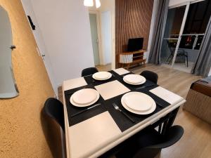 a table with four white plates on top of it at Apartamento 2 dorms próximo a UFABC e CPTM in Santo André