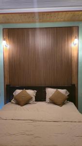a bedroom with a large bed with two pillows at Bale Sunset Inn in Senaru