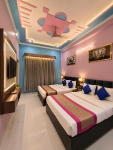 a bedroom with two beds and a flat screen tv at Viraj Guest House in Ayodhya