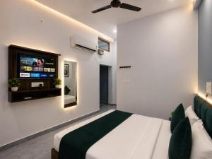a bedroom with a bed and a flat screen tv at Viraj Guest House in Ayodhya