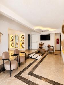 ein Wohnzimmer mit Stühlen, einem Tisch und einem Fernseher in der Unterkunft Mendos Garden Exclusive Hotel Fethiye in Fethiye
