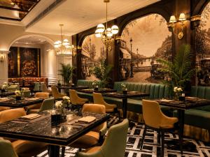 a restaurant with tables and chairs and a mural at Classyc Hotel Hang Buom in Hanoi