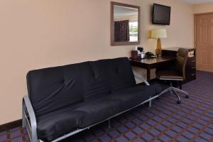 a couch in a room with a desk and a computer at Economy Inn Ardmore in Ardmore