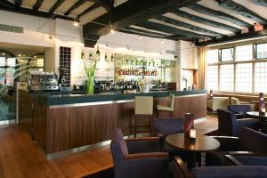 a bar in a restaurant with tables and chairs at ABode Canterbury in Canterbury