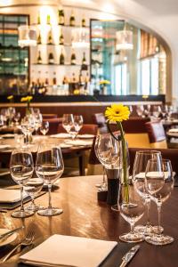 a table with wine glasses and a yellow flower on it at ABode Canterbury in Canterbury