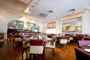 a restaurant with tables and chairs and a bar at ABode Canterbury in Canterbury