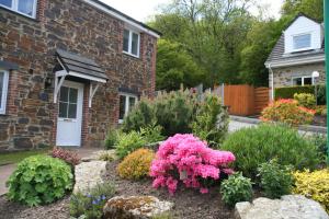 a garden of flowers in front of a house at Crylla Valley Cottages in Saltash
