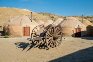a wooden wagon in front of a group of tents at Besqala Yurt Camp in Kabanbay +9 photos