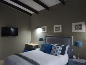 a bedroom with a bed and a flat screen tv at the Host at Bingos House Self Catering in Thohoyandou +25 photos