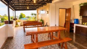 a kitchen with wooden tables and benches in a room at Villa Lourdes in Alaminos