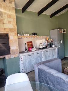 a kitchen with a refrigerator and a couch in a room at the Host at Bingos House Self Catering in Thohoyandou