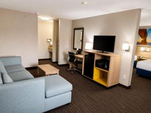 a hotel room with a couch and a tv and a bed at Days Inn by Wyndham Rio Rancho in Rio Rancho