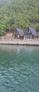 a house on the shore of a body of water at Mrizi i Drinit in Arrëz +2 photos