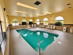 a large swimming pool in a large room with chairs and tables at Days Inn by Wyndham Rio Rancho in Rio Rancho