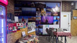 a room with a table and a wall with posters at Besqala Yurt Camp in Kabanbay