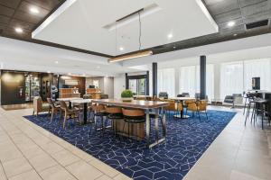 Eine Lobby mit Tischen und Stühlen auf einem blauen Teppich in der Unterkunft Courtyard by Marriott Columbus in Columbus