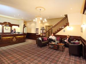 a lobby with two people sitting in a waiting room at Imperial Hotel in Great Yarmouth