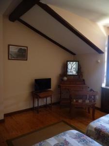 
a living room with a tv and a bed at Hotel Casas del sevillano in El Tornadizo
