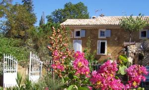 ヴェゾン・ラ・ロメーヌにあるChambre d'hôtes Au coquin de sortの白塀とピンクの花の家