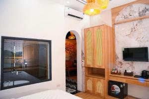 a bedroom with a large mirror and a tv at Thong Dong homestay&villas in Ninh Binh