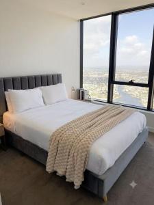 a bedroom with a large bed with a large window at OMI Collection Broadbeach in Gold Coast +12 photos