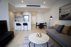 a living room with a couch and a table at OMI Collection Broadbeach in Gold Coast