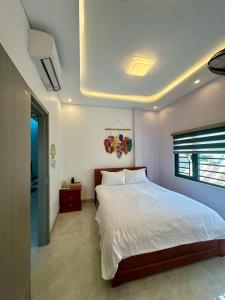 a bedroom with a large white bed and a window at Quỳnh s House in Tân Hiệp