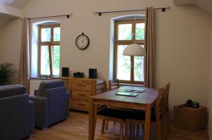ein Wohnzimmer mit einem Tisch und einer Uhr an der Wand in der Unterkunft Forsthaus Sommerswalde in Sommerswalde