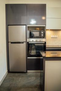 a kitchen with a refrigerator and a microwave at US Apartment in Nochchiyagama