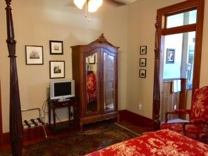 a bedroom with a tv and a dresser with a dresser at 1896 O'Malley House in New Orleans +20 photos