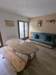 a living room with a wooden table and a couch at Appartement au centre de Barèges in Barèges