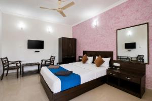 a bedroom with a large bed and a mirror at Sunlight Stay at Goa in Calangute
