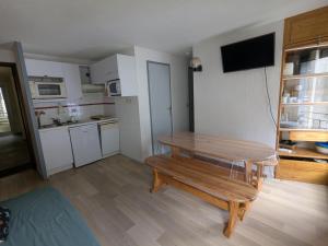 a small kitchen with a wooden table in a room at Appartement au centre de Barèges in Barèges