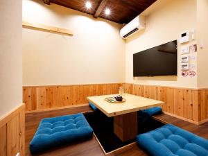 a conference room with a table and a flat screen tv at 奈良旅館 VILLA East West in Nara