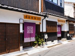 a building with purple doors and a sign on it at 奈良旅館 VILLA East West in Nara