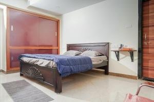 a bedroom with a bed with a wooden headboard at My3 rooms in Vijayawāda