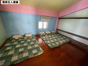 an empty room with four beds in a room at 蘭嶼雅美民宿 in Yeh-yin