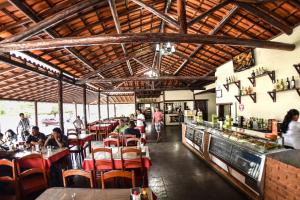 a restaurant with people sitting at tables and a bar at Hotel e Restaurante Sabor de Minas in Salinas