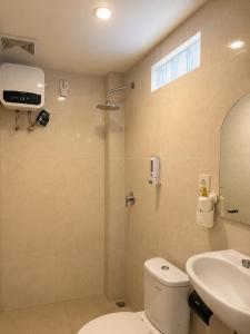 a bathroom with a shower and a toilet and a sink at Braban Sari Guest House Seminyak in Seminyak +3 photos